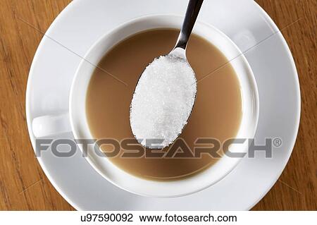 Stock Image - Cup of tea with spoonful of sugar. Fotosearch