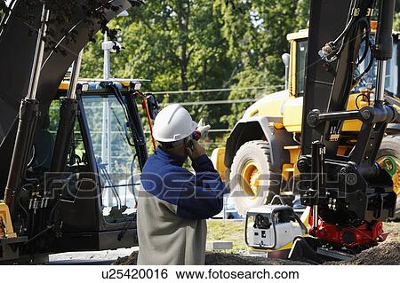 Engineer on phone on construction site View Large Photo Image Stock Photograph - Engineer on phone on construction site. Fotosearch