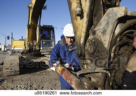 Stock Image - Engineer working with machinery. Fotosearch