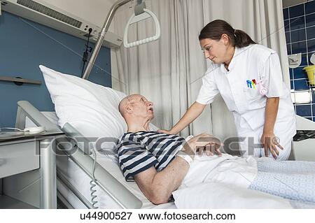 Stock Photo - Female nurse with hand on patient's shoulder. Fotosearch