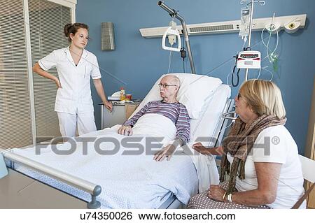 Female visitor and nurse talking to senior man View Large Photo Image Stock Photograph - Female visitor and nurse talking to senior man. Fotosearch