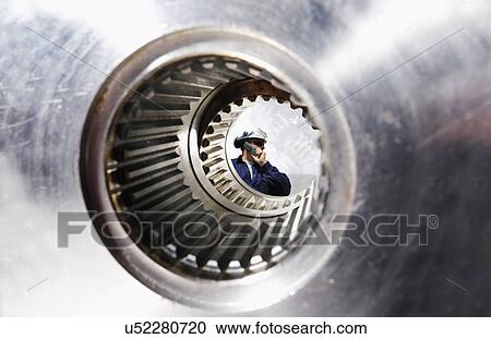Stock Image - Gears and cogs with engineer. Fotosearch