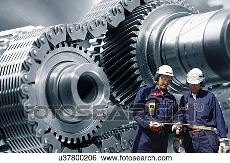 Stock Photograph - Industrial workers with metal cogs. Fotosearch