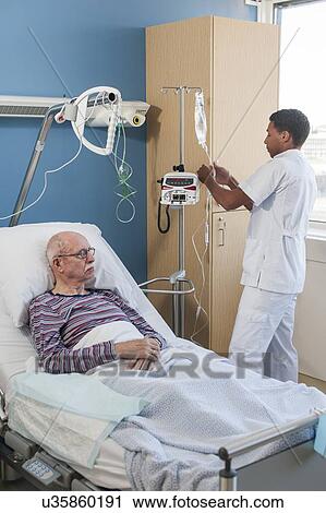 Stock Image - Male nurse treating senior man. Fotosearch
