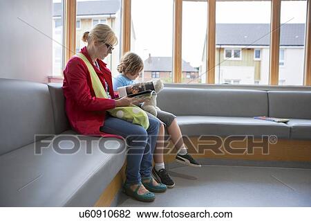 Stock Image - Mother and son in waiting room. Fotosearch