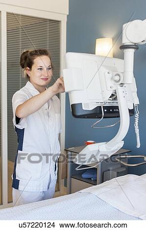 Picture - Nurse checking monitor on hospital bed. Fotosearch