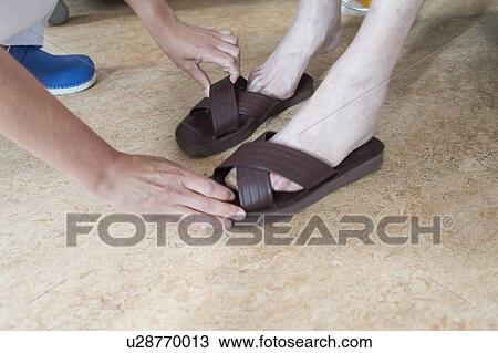 Nurse helping male patient to put sandals on View Large Photo Image Stock Image - Nurse helping male patient to put sandals on. Fotosearch