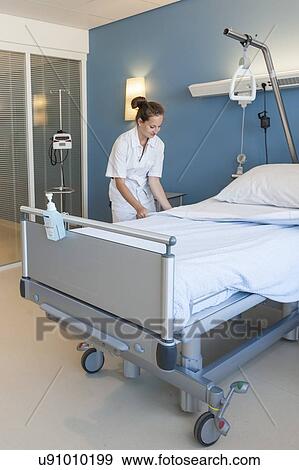 Stock Photo - Nurse making hospital bed. Fotosearch