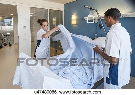 Nurse making hospital bed View Large Photo Image Stock Photograph - Nurse making hospital bed. Fotosearch