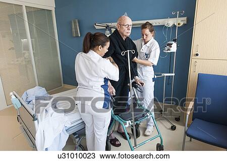 Stock Image - Nurses helping senior male ward. Fotosearch
