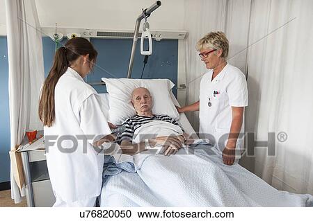 Stock Image - Nurses with Patient. Fotosearch