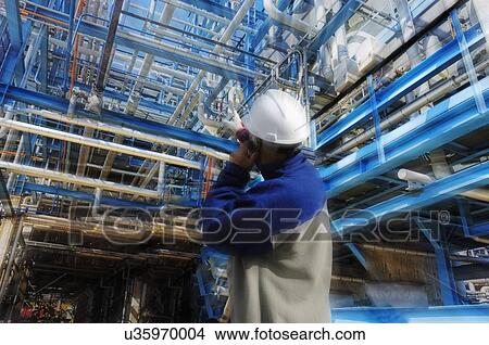 Oil and gas worker inside refinery View Large Photo Image Picture - Oil and gas worker inside refinery. Fotosearch