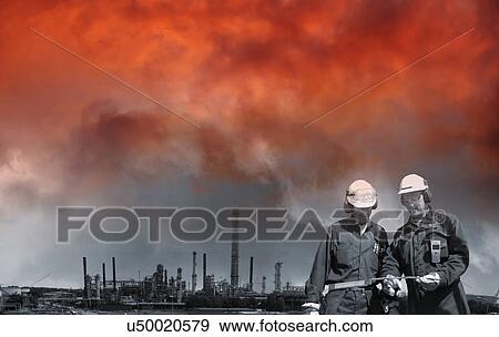 Stock Photo - Oil and gas workers with red sky. Fotosearch