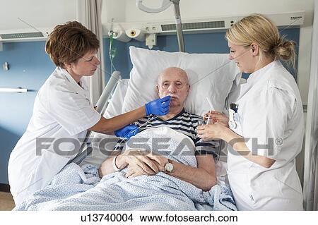 Picture - Patient with nurses. Fotosearch