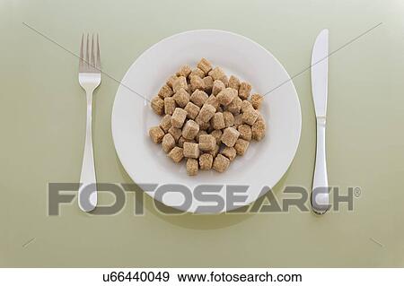Stock Photo - Pile of sugarlumps on dinner plate, studio shot. Fotosearch