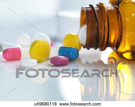 Pills spilling out of a bottle View Large Photo Image Stock Photo - Pills spilling out of a bottle. Fotosearch