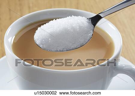 Stock Image - Spoonful of sugar and hot drink. Fotosearch