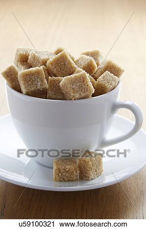 Stock Image - Tea cup full of sugar lumps. Fotosearch
