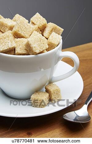 Stock Image - Tea cup full of sugar lumps. Fotosearch
