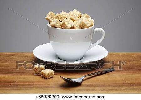 Stock Photo - Tea cup full of sugar lumps. Fotosearch