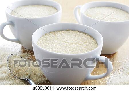 Stock Image - Tea cup full of sugar. Fotosearch