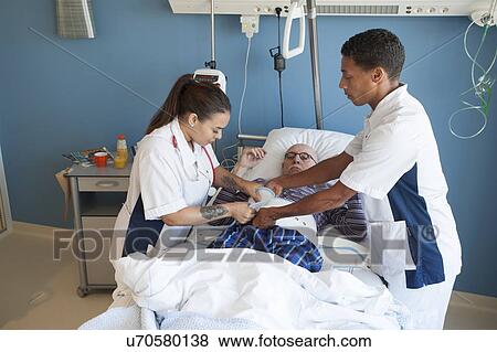 Two nurses fastening medical restraint View Large Photo Image Stock Photo - Two nurses fastening medical restraint. Fotosearch