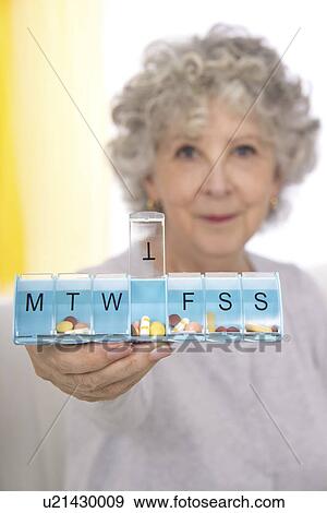 Woman holding pill organiser View Large Photo Image Stock Photo - Woman holding pill organiser. Fotosearch