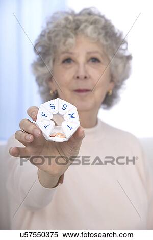 Stock Photography - Woman holding pill organiser. Fotosearch