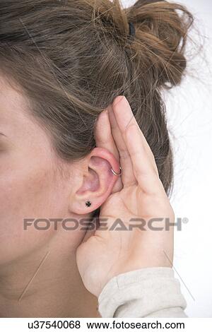 Woman with hand cupped to ear View Large Photo Image Stock Photo - Woman with hand cupped to ear. Fotosearch