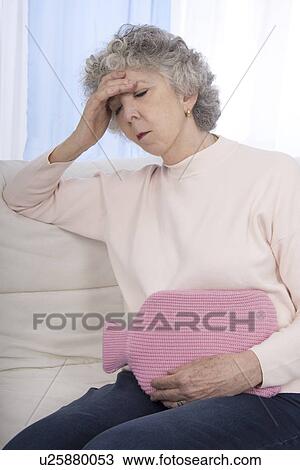 Stock Image - Woman with hot water bottle. Fotosearch