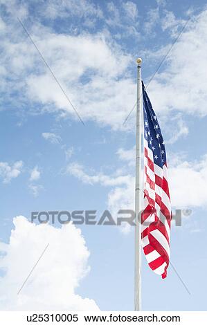 Stock Photography - American flag against blue sky. Fotosearch