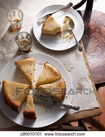 Stock Image - Bistro dessert of sliced New York cheesecake on table. Fotosearch