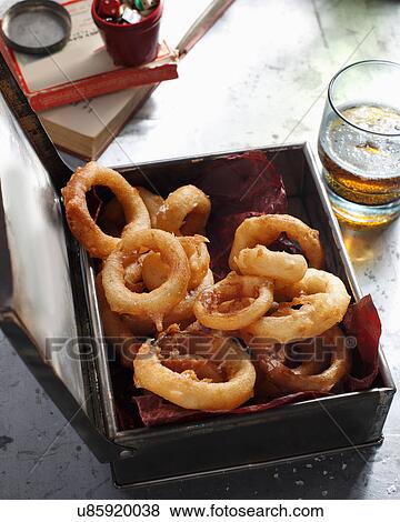 Bistro meal of deep fried onion rings and beer on table View Large Photo Image Stock Photo - Bistro meal of deep fried onion rings and beer on table. Fotosearch