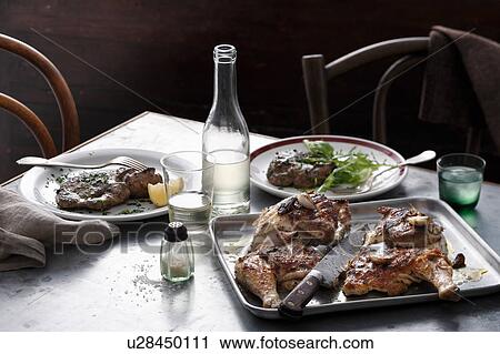 Stock Image - Bistro meal of roast spatchcock and calf liver with white wine on table. Fotosearch