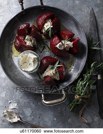 Stock Image - Bistro table with dish of whole beetroots, horseradish and tarragon. Fotosearch