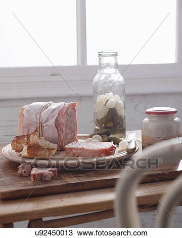 Stock Image - Bistro table with pork terrine, pickled onions and cornichon. Fotosearch