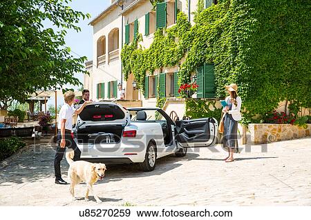 Boutique hotel porter getting luggage for couple arriving in convertible, Majorca, Spain View Large Photo Image Stock Photo - Boutique hotel porter getting luggage for couple arriving in convertible, Majorca, Spain. Fotosearch