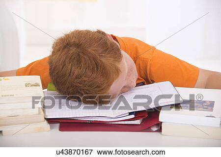 Stock Photo - Boy asleep with head on school books. Fotosearch