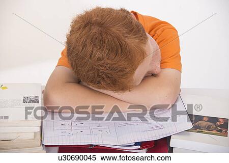 Stock Photography - Boy asleep with head on school books. Fotosearch