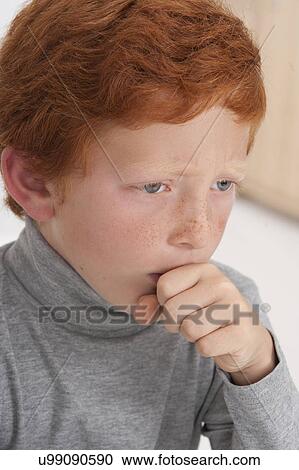 Stock Image - Boy coughing with hand over mouth. Fotosearch