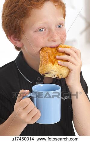 Boy eating food and holding mug View Large Photo Image Picture - Boy eating food and holding mug. Fotosearch