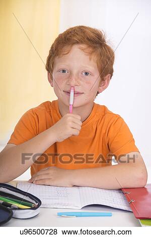 Boy holding pen doing homework View Large Photo Image Stock Photo - Boy holding pen doing homework. Fotosearch