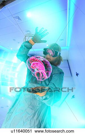 Stock Image - Boy in virtual reality headset interacting with digital floating human brain. Fotosearch