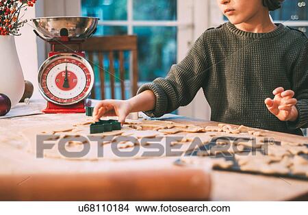 Picture - Boy preparing Christmas cookies at kitchen counter. Fotosearch
