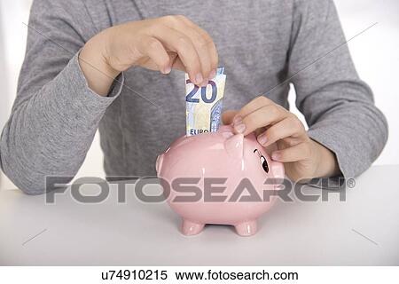 Boy putting money in piggy bank View Large Photo Image Stock Photography - Boy putting money in piggy bank. Fotosearch