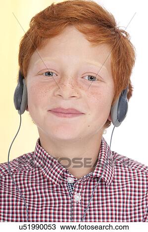Stock Image - Boy wearing headphones smiling. Fotosearch