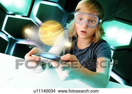 Boy with hand held computer staring at digital spinning planet View Large Photo Image Picture - Boy with hand held computer staring at digital spinning planet. Fotosearch