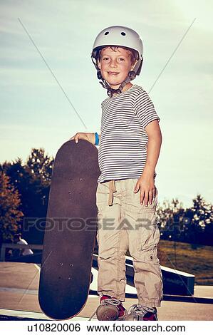 Stock Photograph - Boy with skateboard in park. Fotosearch