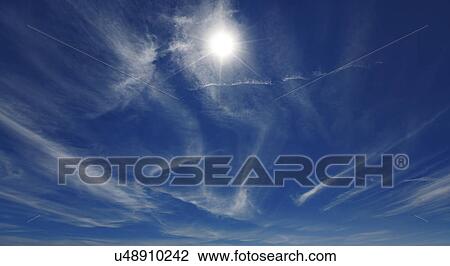 Stock Image - Bright sun in blue sky. Fotosearch