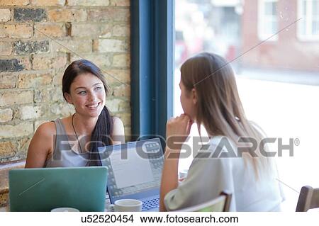 Picture - Businesswomen having meeting in coffee bar, London. Fotosearch